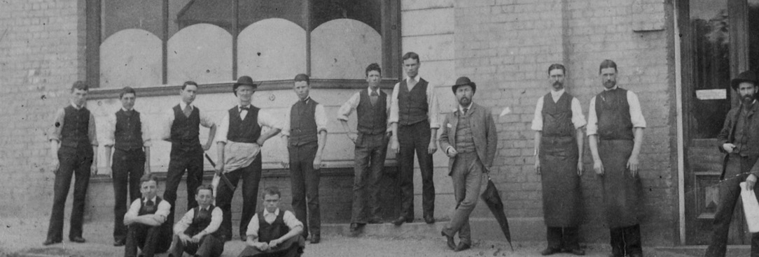 Black and white photo of men outside a store